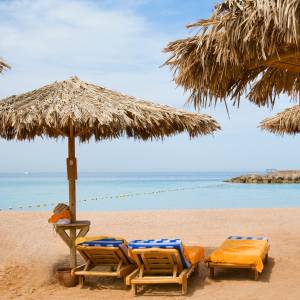 Ägyptisches Strandparadies mit Palmen und Liegestühlen